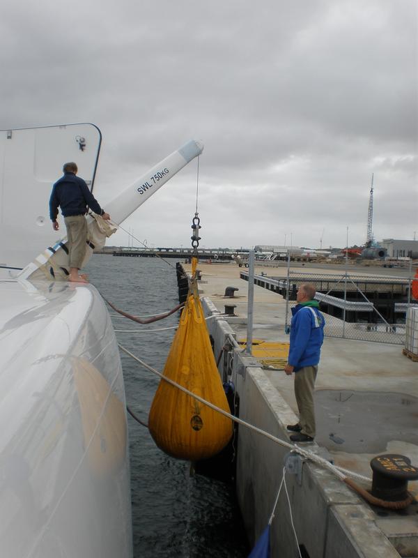 Custom carbon crane handling equipment alongside a yacht