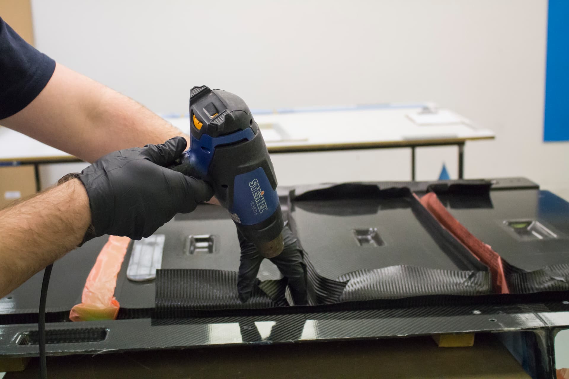 Technician laying up pre-preg carbon fibre in a mould