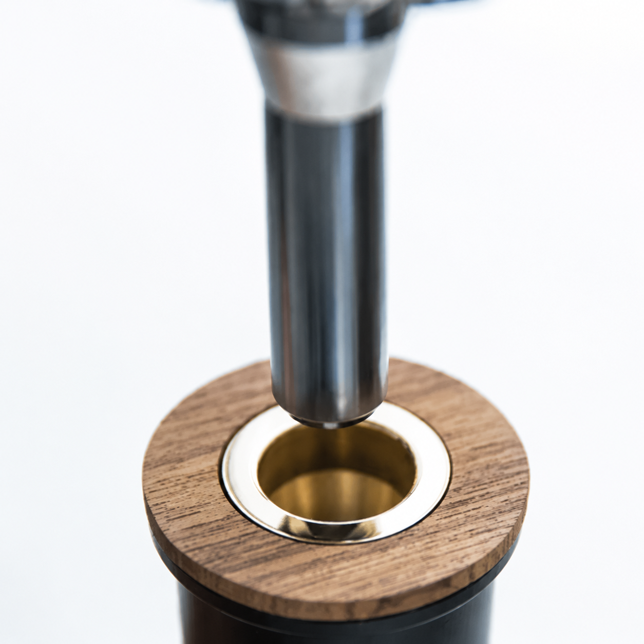 Close-up of a flush teak deck socket receiving the swim ladder's polished stanchion