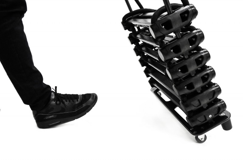 C-Quip pilot ladder steps stacked flat on a wheeled trolley beside a crew member